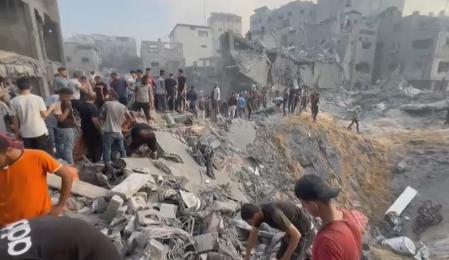 Palestinos buscan supervivientes bajo los escombros de un edificio destruido tras los ataques aéreos israelíes en el campo de refugiados