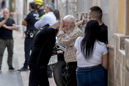 Varios vecinos afligidos esperan a las puertas de la vivienda de un matrimonio que han fallecido junto a su hijo esta tarde en el incendio de su vivienda en la localidad murciana de Ceutí, al parecer por falta de oxígeno, ya que los cuerpos no se encontraban calcinados.