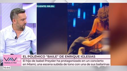 Enrique Iglesias cantando con la cabeza entre las piernas de una bailarina