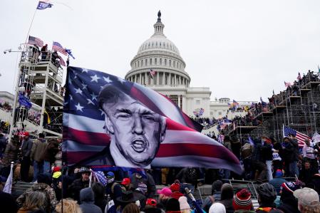Fotografía de archivo fechada el 6 de enero de 2021 donde aparecen varios simpatizantes del presidente Trump ondeando banderas con su imagen durante el asalto al Capitolio en Washington (EE.UU)