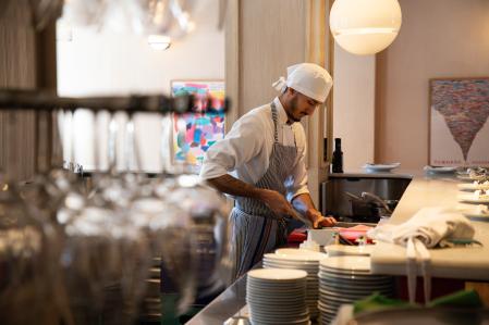 La barra redonda del centro del local, en la que se preparan algunas elaboraciones, persigue facilitar la conversación entre comensales y trabajadores