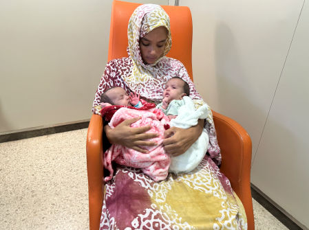 La madre sostiene a las niñas separadas