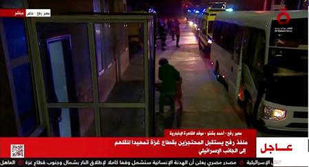 Algunos de los rehenes liberados por Hamas bajan de algunos vehículos en el paso fronterizo con Gaza