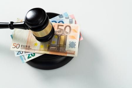 Gavel with stack European Union currency on white background.