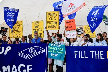 Activists hold placards and shout slogans during a protest, at the United Nations Climate Change Conference COP28 in Dubai, United Arab Emirates, December 6, 2023. REUTERS/Thaier Al-Sudani