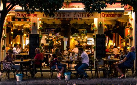 Seville, SPAIN - October 18, 2016: Strolling through the center of Seville I stop watching this scene. In Calle Mateos Gago some people, including tourists, are having dinner in this restaurant, very typical.