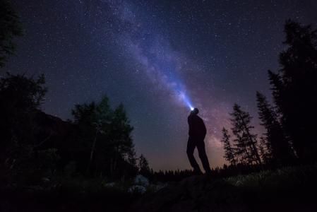 Man with headlamp looking at the stars