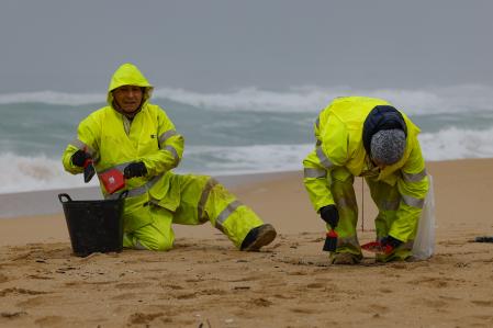 RIBEIRA (A CORUÑA), 09/01/2024.- Operarios de empresas contratadas por la Xunta retiran los pellets o bolitas para fabricar plástico que aparecen en las playas gallegas y de Asturias, tras la caída de un contenedor de un barco el pasado diciembre, esta mañana en la playa de O Vilar, en el parque natural de Corrubedo, A Coruña. EFE/Lavandeira jr