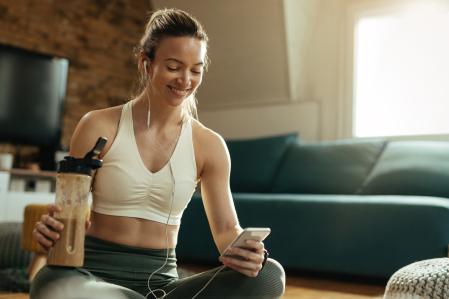 Una mujer tomando un batido de proteínas después de entrenar.