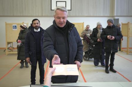Green Party backed candidate Pekka Haavisto casts his vote with his partner Antonio Flores, background left, in Helsinki, Finland, Sunday, Feb. 11, 2024. Finnish voters are choosing between two experienced politicians to be their next president. The winner's main task will be to steer the Nordic country’s foreign and security policy now that it is a member of NATO, following Russia’s invasion of Ukraine. Center-right former prime minister Alexander Stubb and former foreign minister Pekka Haavisto, from the green left, largely agree on Finland’s foreign policy and security priorities. (AP Photo/Sergei Grits)