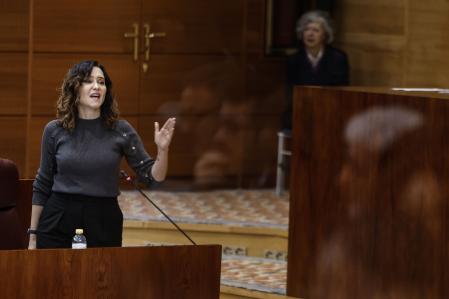 La presidenta de la Comunidad de Madrid, Isabel Díaz Ayuso (d), interviene en el pleno de la Asamblea de Madrid, este jueves