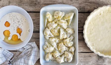 Tres recipientes con huevos y nata para cocinar, coliflor y masa brisa