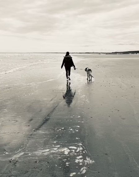 Daniella paseando por la playa junto a su perro