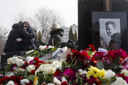 A person embraces Russian opposition leader Alexei Navalny's mother, Lyudmila Navalnaya, left, while his mother-in-law, no name available, center, stands near while visiting the grave of Alexei Navalny after his yesterday funeral at the Borisovskoye Cemetery, in Moscow, Russia, on Saturday, March 2, 2024. Navalny, who was President Vladimir Putin's fiercest foe, was buried after a funeral that drew thousands of mourners amid a heavy police presence. (AP Photo)