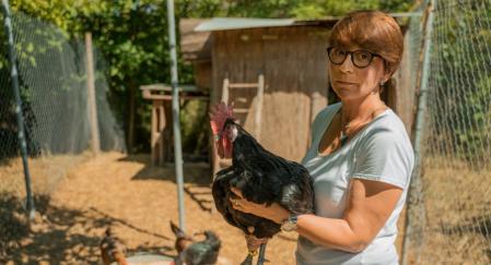 Elisabeth Colomer sujeta uno de los gallos del Penedès que cría