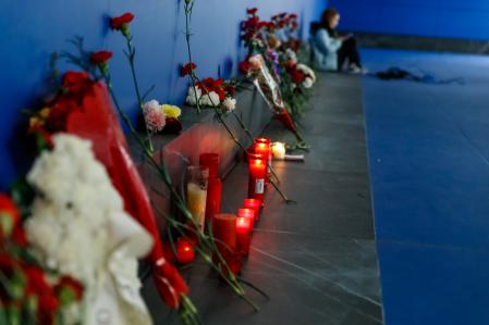 Claveles y un peluche a los pies del panel que recuerda a las víctimas durante el acto celebrado con motivo del XX aniversario de los atentados yihadistas del 11M, este lunes en la estación de Atocha-Cercanías en Madrid