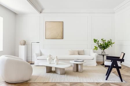 Zona del gran salón donde la mayoría del mobiliario presenta color blanco. Destaca la silla Capitol diseño de Pierre Jeannere