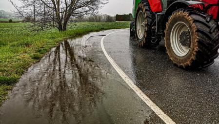 Charco de agua con paisaje verde y el tractor, imagen capturada en Sentfores.