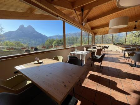 Sala del restaurante con unas grandes cristaleras que nos permite contemplar mientras estamos comiendo el Pedraforca.