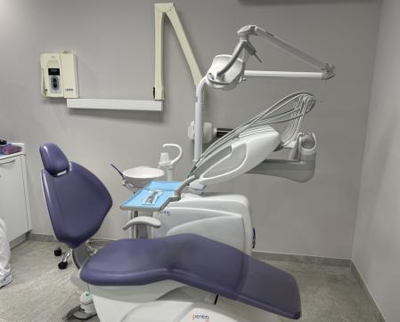 Unidad dental integrada en el consultorio de la sala estomatológica moderna, con el fondo de la silla dental orientado al paciente, instalado en un Box de la clínica dental Daxa, proporcionando un buen campo de visión y espacio de operación y accesorios usados por los dentistas en azul, luz paramédica.
