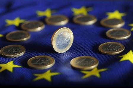 Monedas de euro sobre una bandera europea.