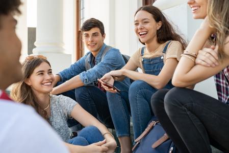 Un grupo de adolescentes conversan a la salida del aula