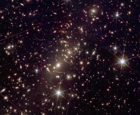 Este detalle de la imagen del cúmulo Abell 2390 muestra los arcos de luz provocados por el efecto de lente gravitacional y que delatan la presencia de galaxias muy lejanas