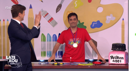 Jordi Cruz, conocido presentador de 'Art Attack', muestra cómo montar una medalla con pegamento y lazo en 'LateXou', ironizando sobre la falta de seriedad del protocolo de la RFEF