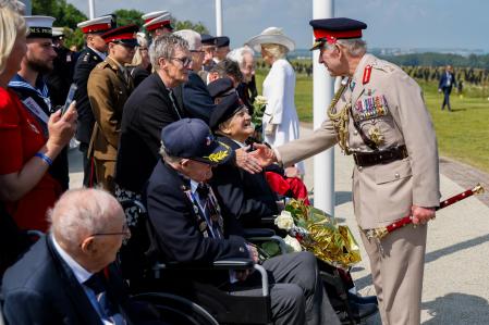 El rey Carlos III saluda a los veteranos británicos de la Segunda Guerra Mundial durante la ceremonia conmemorativa.