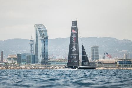 El AC75 American Magic navega a gran velocidad por delante del hotel Vela durante los entrenamientos en Barcelona