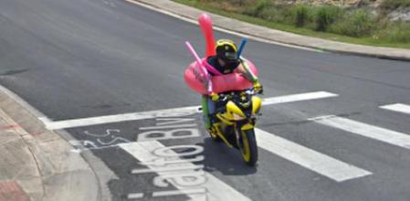 Usuario con enorme flotador en forma de cisne rosa