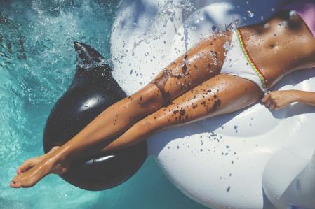 Una mujer bronceándose en la piscina.