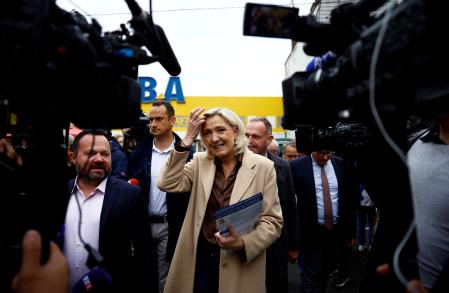 Marine Le Pen, French far-right leader and French far-right National Rally (Rassemblement National - RN) party candidate in the upcoming parliamentary elections, distributes leaflets as she campaigns with Henin-Beaumont mayor Steeve Briois and local RN politician Bruno Bilde at a market in Henin-Beaumont, northern France, June 14, 2024. REUTERS/Sarah Meyssonnier      TPX IMAGES OF THE DAY