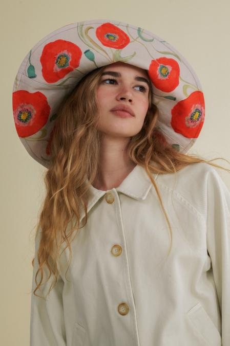 Sombrero reversible estampado con dibujo de amapolas rojas sobre fondo crema pintado a mano por la directora creativa de la marca