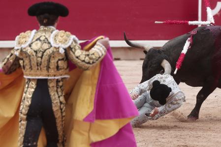 Un banderillero de la cuadrilla del diestro Gómez del Pilar es alcanzado por el quinto toro de la tarde dentro de la Feria del Toro de los Sanfermines