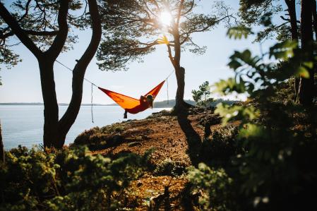 Summer in Norway: adventures in nature outdoor on hammock, by a fjord in Norway