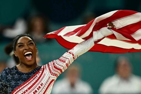 TOPSHOT - US' Simone Biles celebrates after team USA won the artistic gymnastics women's team final during the Paris 2024 Olympic Games at the Bercy Arena in Paris, on July 30, 2024. (Photo by Loic VENANCE / AFP)