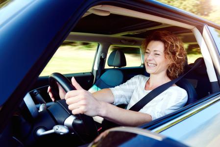 Una mujer sonriendo al volante