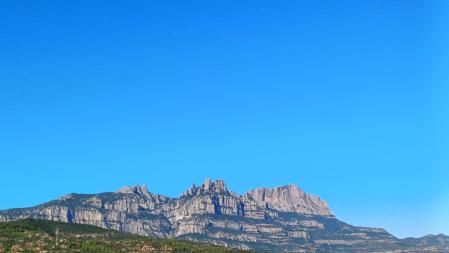 Montserrat vista desde el Parc de l'Agulla en un día de cielo azul y claro.