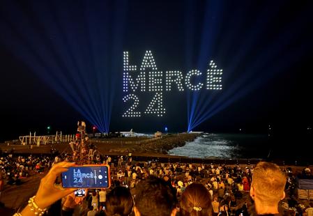 Locals and tourists look at 300 drones lighting the sky, by Flock Drone Art, on the Barceloneta beach, to mark Barcelona's patroness, La Merce, in Barcelona, Spain September 22, 2024. REUTERS/Nacho Doce