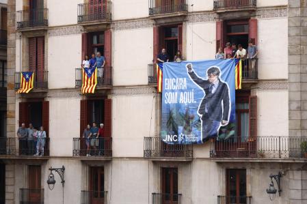 BARCELONA, 22/09/2024.- Miembros de las Juventudes Nacionalistas de Cataluña (JNC) cuelgan una pancarta alusiva al ex presidente Carles Puigdemont durante la primera diada castellera de la Mercè 2024 en la Plaça de Sant Jaume de Barcelona durante las fiestas de La Mercè. EFE/Quique García