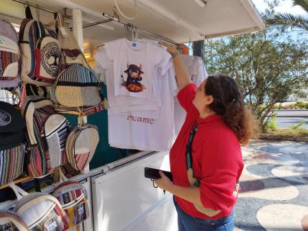 Verónica Labrador muestra camisetas que ella misma diseña y vende en el puesto que regenta.