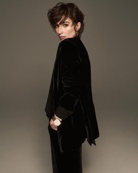 Traje esmoquin de terciopelo con camisa de gasa negra con lazada al cuello de Parosh. Reloj de la colección Alpine Eagle de oro rosa ético y acero Lucent Steel, de 41 mm 
con esfera gris Bernina, movimiento automático C O1.01 de Chopard, pulseras de oro blanco, rosa y amarillo engastadas de diamantes y pendientes de oro rosa