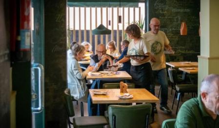 Uno de los comedores de Aüc Bar, decorados con recetas de cocina catalana en las paredes