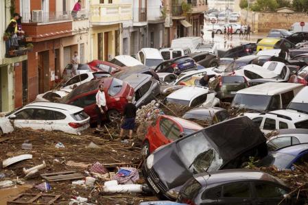 Coches apelmazados sobre la carretera destrozada a consecuencia de la DANA
