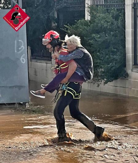 Un bombero rescata a una persona afectada por la DANA