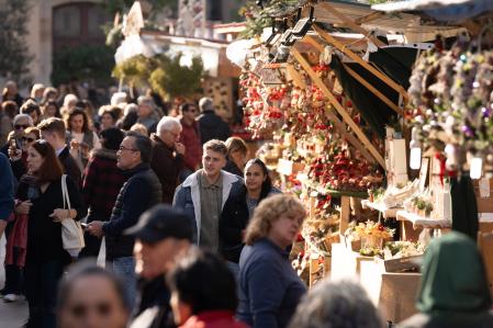 Varias personas observan el ambiente navideño en la Fira de Santa Llúcia de Barcelona, en la plaza de la Catedral, a 5 de diciembre de 2024, en Barcelona, Catalunya (España). El gasto medio de los españoles previsto para estas Navidades será de 583 euros por persona, lo que supone un aumento del 3% en comparación con las fiestas del año 2023, según el último informe sobre la intención de gasto en Navidad realizado por Observatorio Cetelem. Aquellos consumidores comprendidos entre los 40 y 44 años son quienes estiman gastar más de media durante las fiestas navideñas, unos 711 euros por persona.