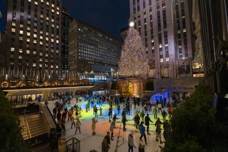 Personas patinan en la pista de hielo junto al árbol del Rockefeller Center