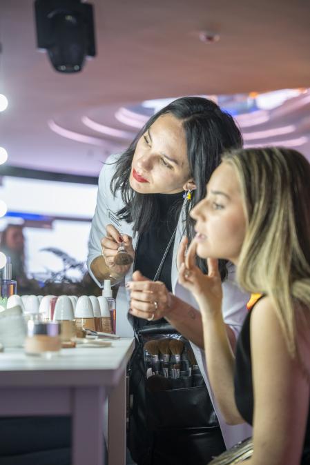 Una chica aprende a encontrar su tono de base de maquillaje en un evento de Clinique