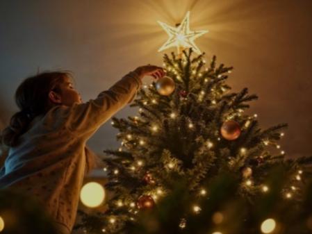 Una niña colocando las luces de Navidad